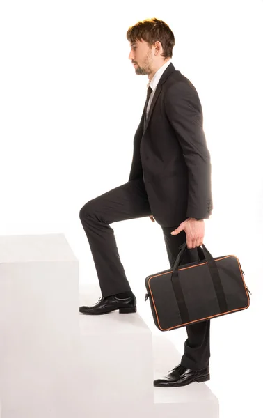 Empresario subiendo escaleras con un maletín —  Fotos de Stock