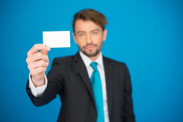 Homem de negócios bonito mostrando cartão de visita em branco — Fotografia de Stock