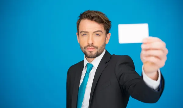 Handsome businessman showing blank business card — Stock Photo, Image