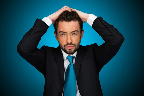 Hombre de negocios flustrado sobre fondo azul  , — Foto de Stock