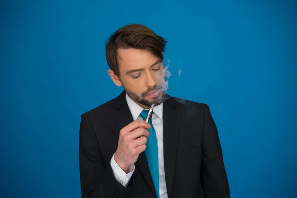 Homme d'affaires avec e-cigarette costume et cravate sur bleu — Photo