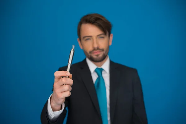 Businessman with e-cigarette wearing suit and tie on blue — Stock Photo, Image