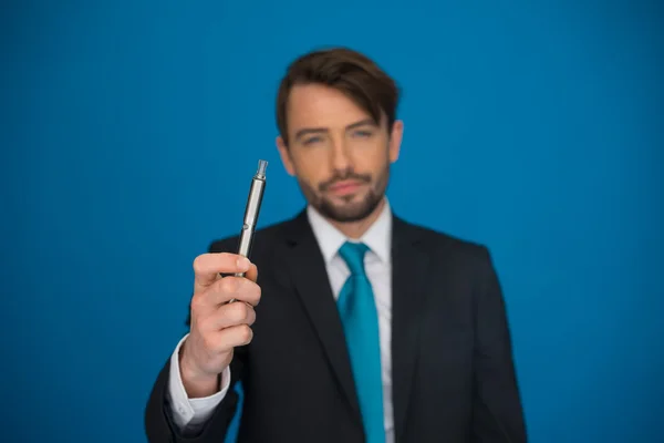 Hombre de negocios con traje y corbata de cigarrillo electrónico en azul — Foto de Stock