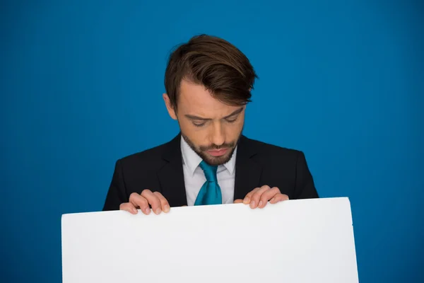 Empresario sosteniendo cartel en blanco — Foto de Stock