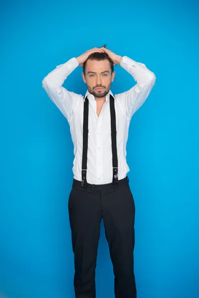 Hombre guapo en azul vistiendo camisa blanca y frenos — Foto de Stock
