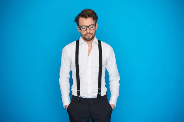 Handsome man on blue wearing white shirt and braces — Stock Photo, Image