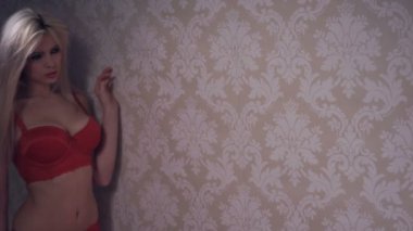 Kırmızı iç çamaşırı giyen seksi sarışın kadın.