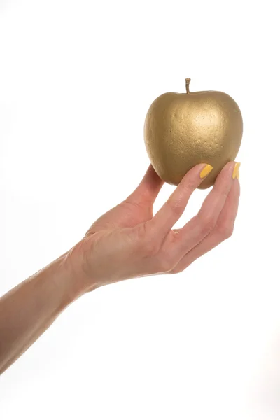 Mão feminina segurando uma maçã dourada — Fotografia de Stock