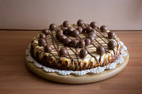 Torta saborosa coberto com bolas de chocolate em um coração — Fotografia de Stock