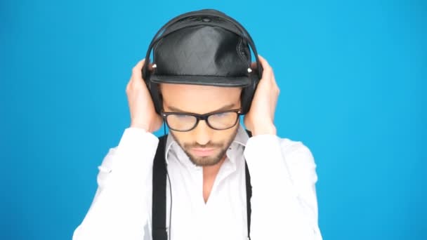 Hombre de moda con sombrero y auriculares escuchando la música — Vídeos de Stock