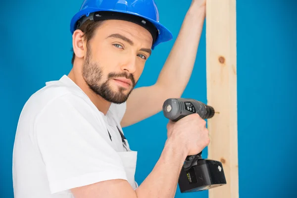 Carpenter drilling a hole in a plank of wood — Stock Photo, Image