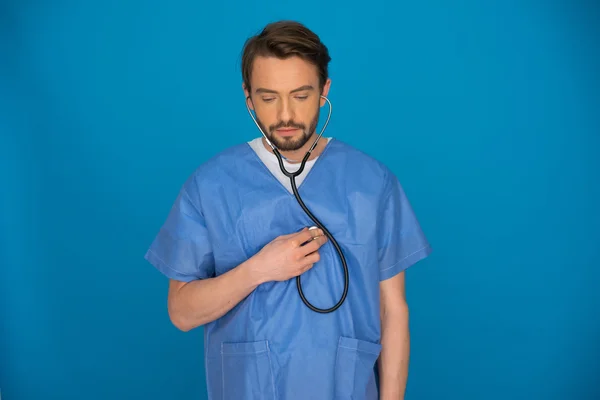 Doctor holding a stethoscope staring at the floor — Stock Photo, Image