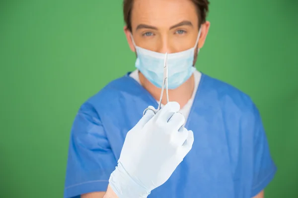 Male nurse or doctor with a pair of forceps — Stock Photo, Image