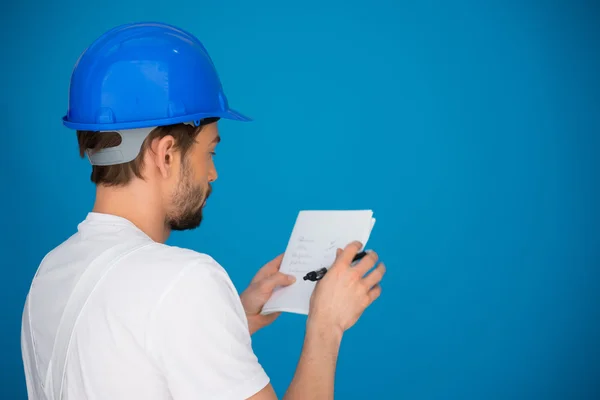 Builder referring to a page of notes — Stock Photo, Image