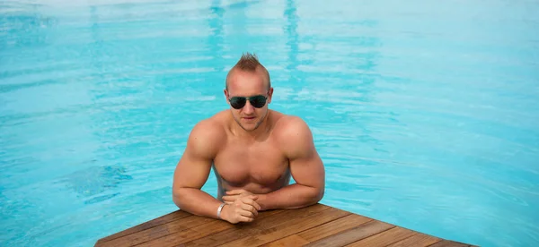 Hombre musculoso posando en la piscina — Foto de Stock