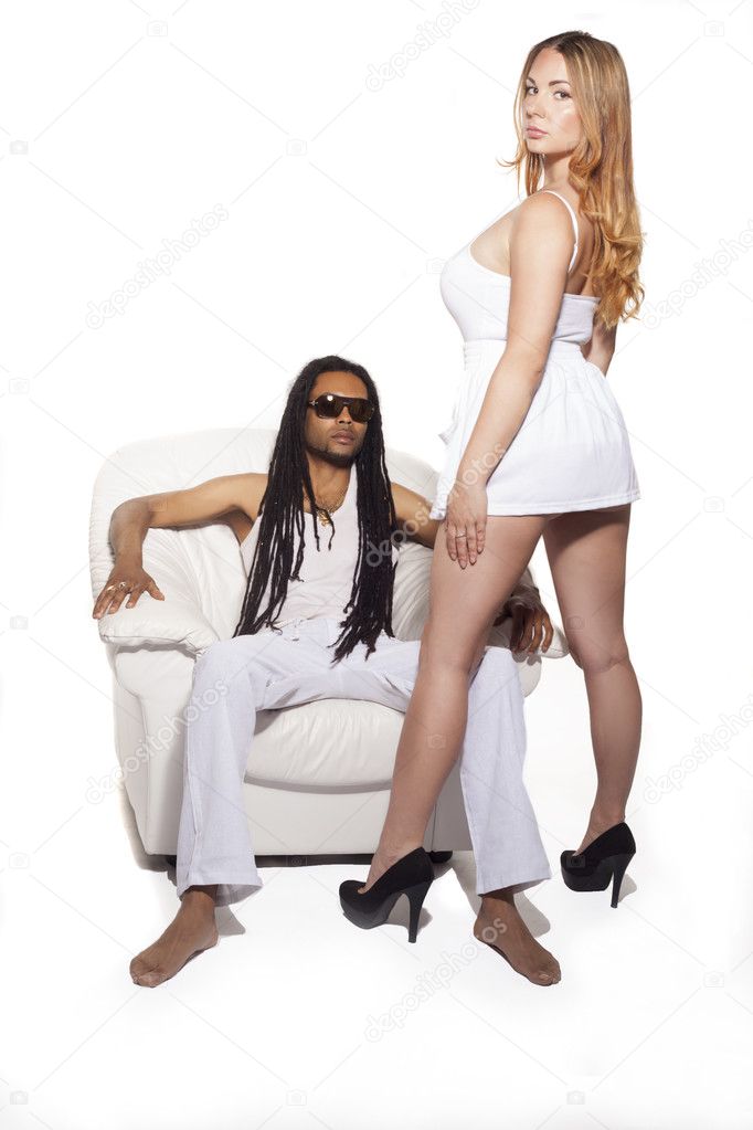 Woman standing over leg of man on couch