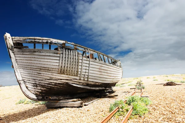 Barca da pesca in legno lasciata a marcire e decadere sulla spiaggia di ghiaia a Dungeness, Inghilterra, Regno Unito . — Foto Stock