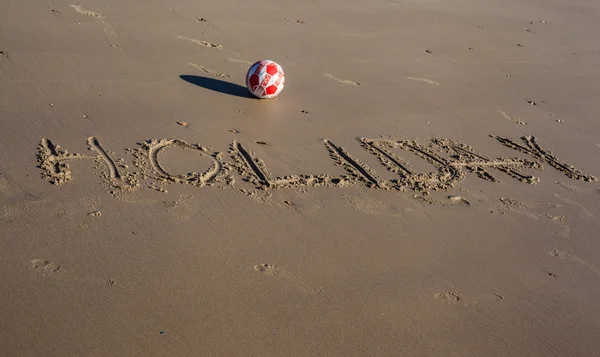 Ordet semester skrivet på sanden på en strand — Stockfoto