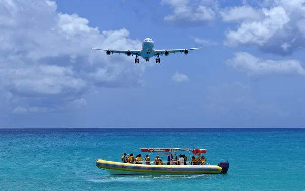 Passenger airplane overflies boat. — Stock Photo, Image