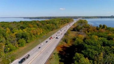 Trans-Canada otoyolu, İki Dağ Köprüsü Gölü ve Montreal 'in kenar mahallelerinde sonbahar mevsimi renkleri. 4K kamera Trans-Canada otoyolunun insansız hava aracı görüntüsü ve sonbahar yeşillik rengi.