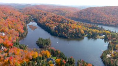 4K kameralı drone, göldeki göz kamaştırıcı sonbahar yeşillik renklerini ve tenha evleri yakalıyor.