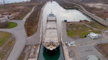 Kanada, St. Lawrence Seaway 'deki Beauharnois Kanalı' nı geçen bir kargo gemisinin 4K hava görüntüsü..