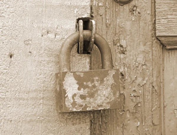 Old lock on a wooden door.Sepia. — Stock Photo, Image