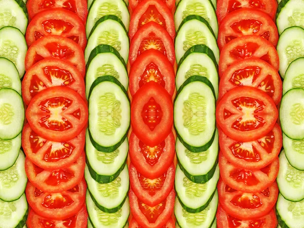 Geschnittene Tomaten und Gurken. Symmetrischer Hintergrund. — Stockfoto