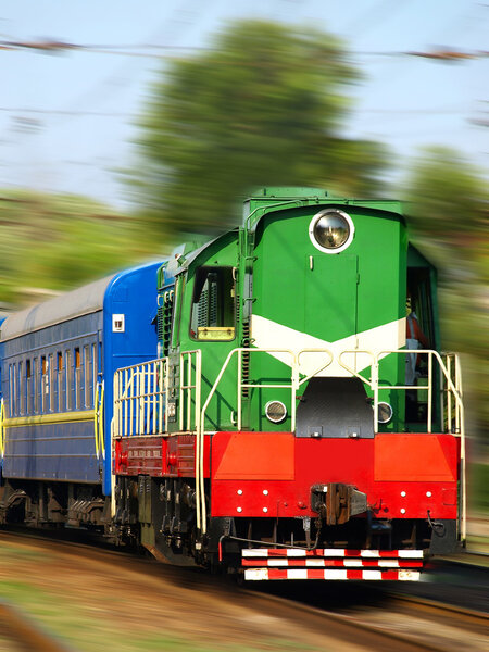 Fast locomotive and passenger cars in movement.