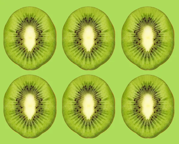 Ripe kiwi slices on green background. — Stock Photo, Image