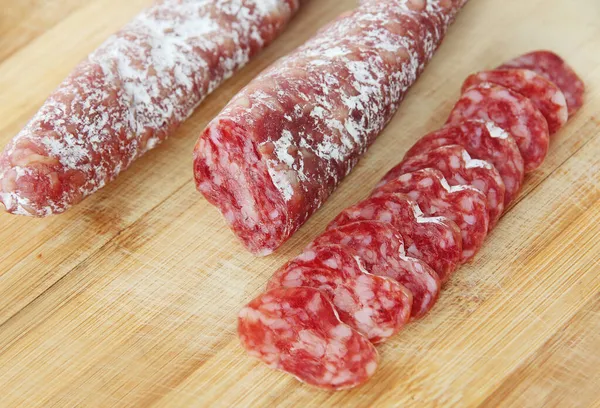 Olgun hava kurutulmuş sosisi. Tahtada dilimlenmiş İspanyol geleneksel sosis Fueti yakından çekildi.