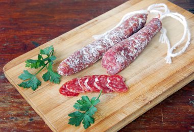 Tahta masada dilimlenmiş İspanyol geleneksel sosis Fuet 'i. Olgun hava kurutulmuş sosis..