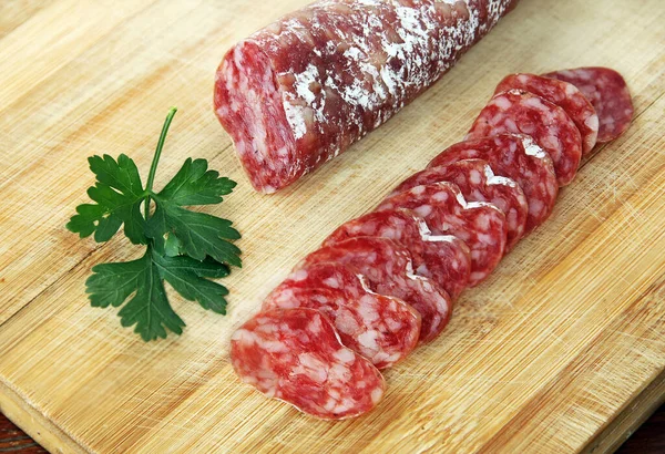 Olgun hava kurutulmuş sosisi. Tahtada dilimlenmiş İspanyol geleneksel sosis Fueti. 