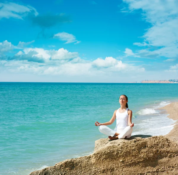 Mujer haciendo yoga cerca del mar — Foto de Stock