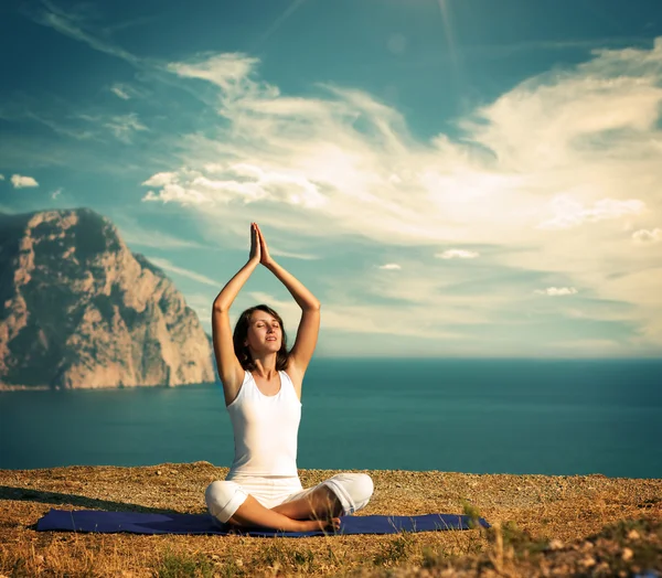 Vrouw doen yoga bij de zee en de bergen — Stockfoto