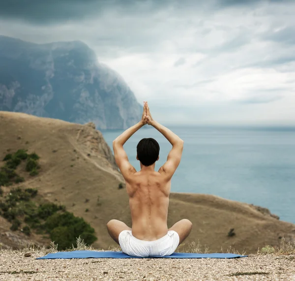 Homem fazendo Yoga no mar e montanhas — Fotografia de Stock