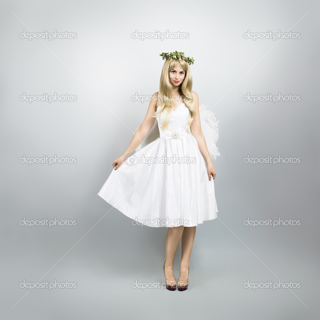 Young Woman in Angel Costume on Gray Background