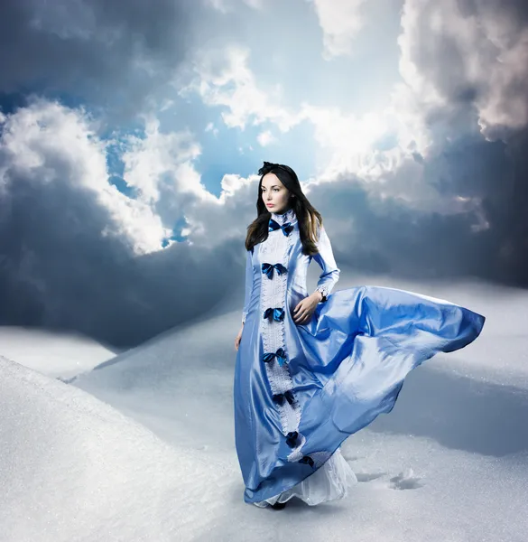 Kvinna i lila klänning går på vintern hills — Stockfoto