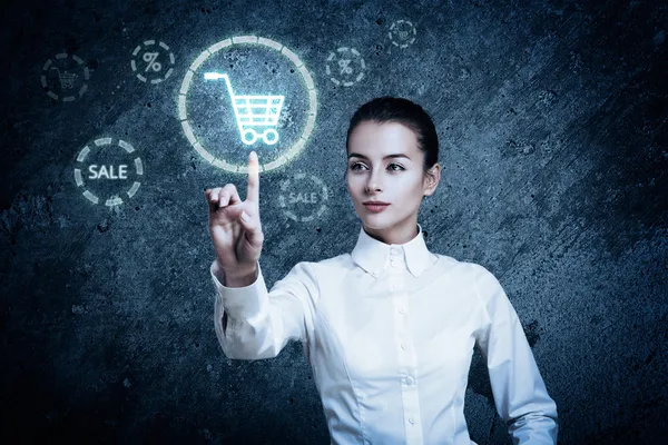 Woman Pointing at Glowing Shopping Cart Icon — Stock Photo, Image