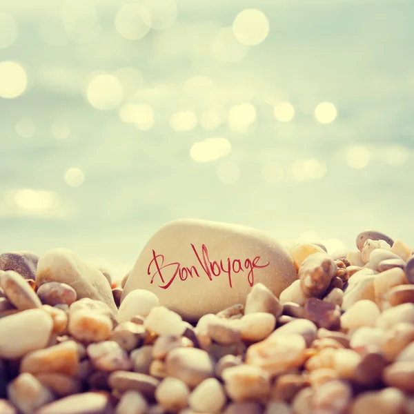 ""bon voyage" -Text auf Stein am Strand geschrieben — Stockfoto