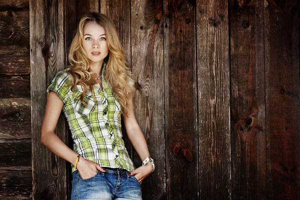 Porträt einer jungen Hipsterfrau an der Holzwand — Stockfoto