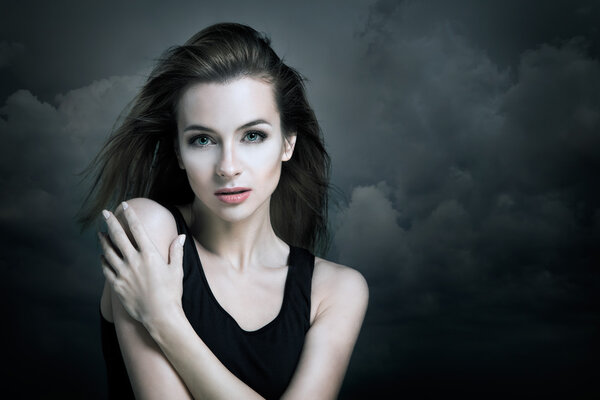 Lonely Woman on the Background of Dark Clouds