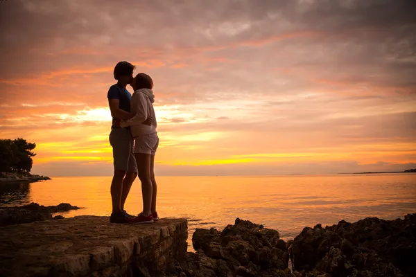 Pareja abrazando y besándose en el mar puesta del sol — Foto de Stock