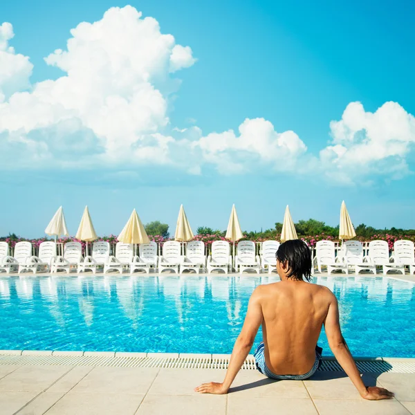 Pohledný muž relaxační poblíž venkovní bazén — Stock fotografie