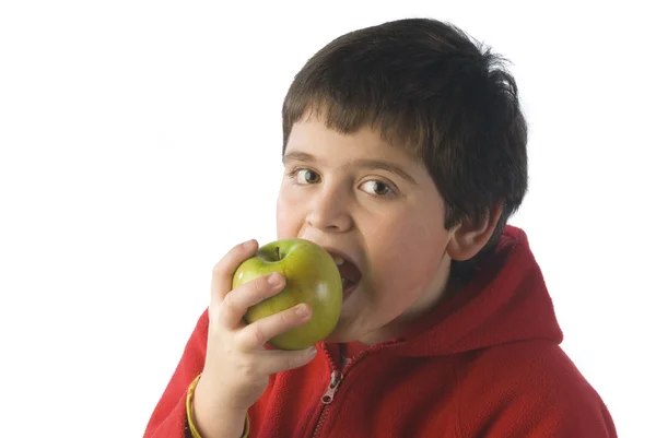 Child biting a green apple with red shirt — Stock Photo, Image