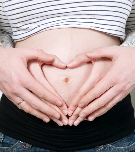 Coração feito na barriga da mulher grávida — Fotografia de Stock