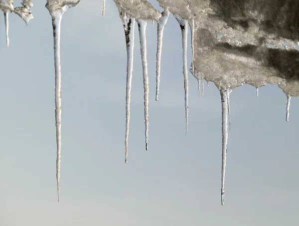 Bulutlu gökyüzü arka plan üzerinde buz sarkıtları çerçeve — Stok fotoğraf