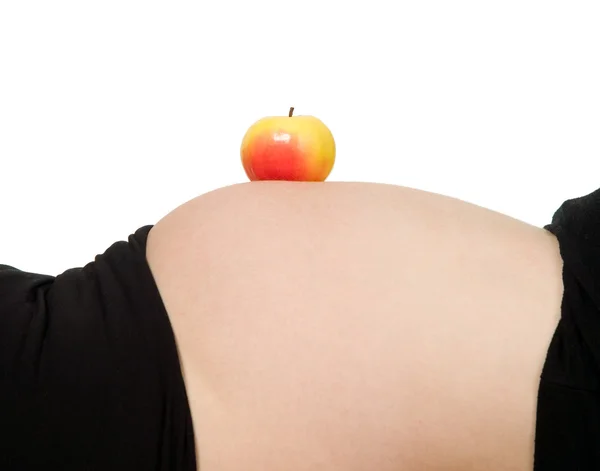 Apple på en gravid mage — Stockfoto