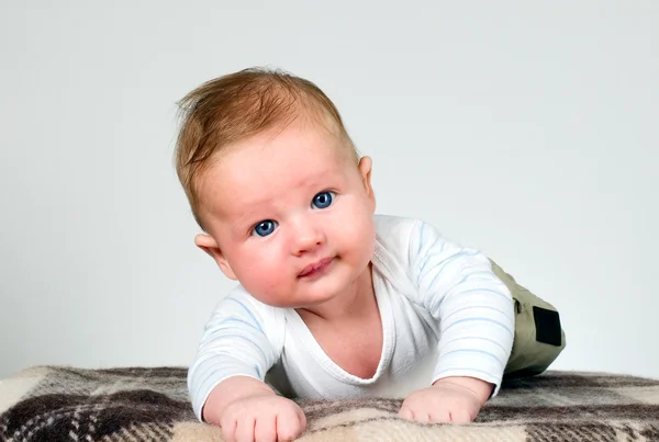 Baby boy holds raised head — Stock Photo, Image