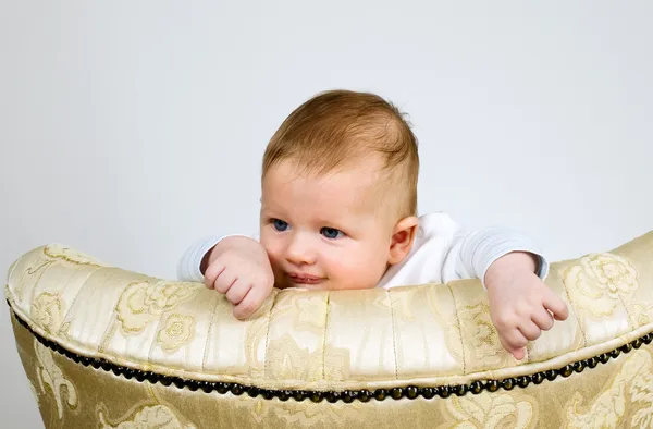 Ragazzo sta guardando attraverso una parte superiore della sedia — Foto Stock